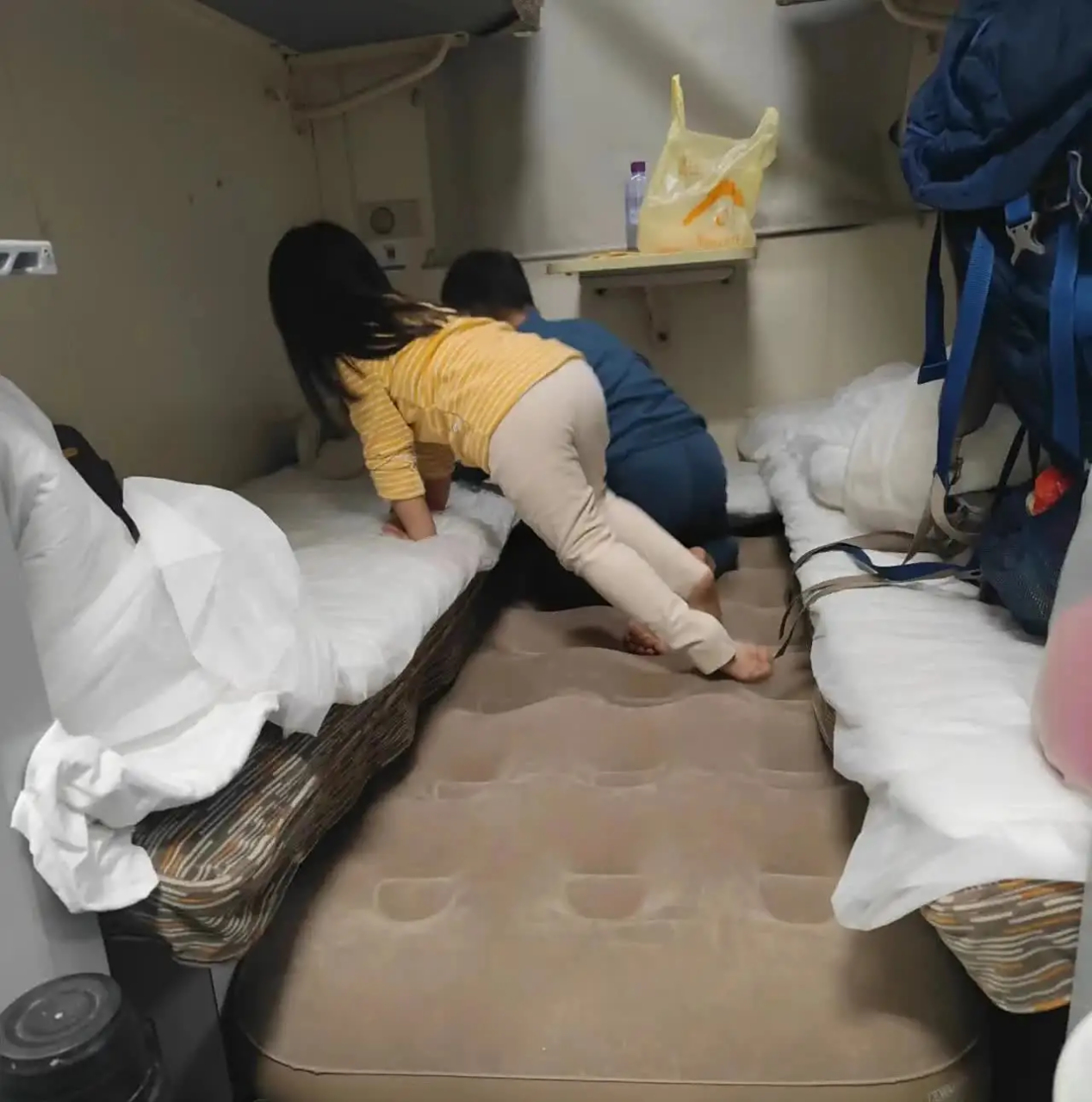 广州东发往哈尔滨西的z236列车卧铺上,一位携带两个孩子的家长自备了