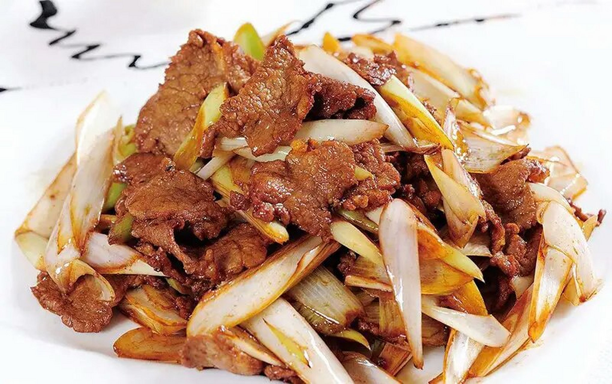 葱爆羊肉 剔去羊肉上的筋膜,用温水漂洗30分钟以去除血污和膻脂,使