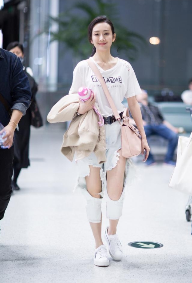 王鸥下身穿搭九分长度的破洞牛仔裤,脚踩白色帆布鞋,休闲度假风造型