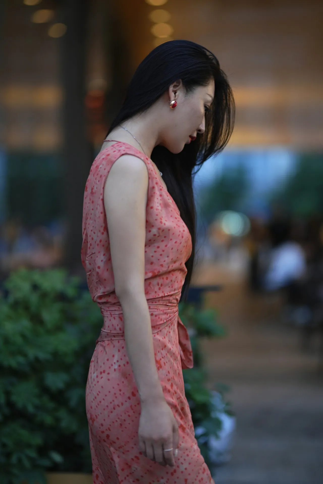 捕捉到一位气质美女的侧影,她身着一袭桃红色连衣裙,在街头漫步,显得