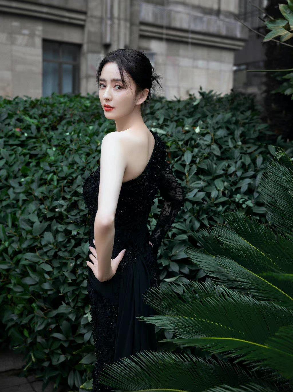 佟丽娅一袭黑衣,坦露性感的左侧肩颈臂膀和玉手.