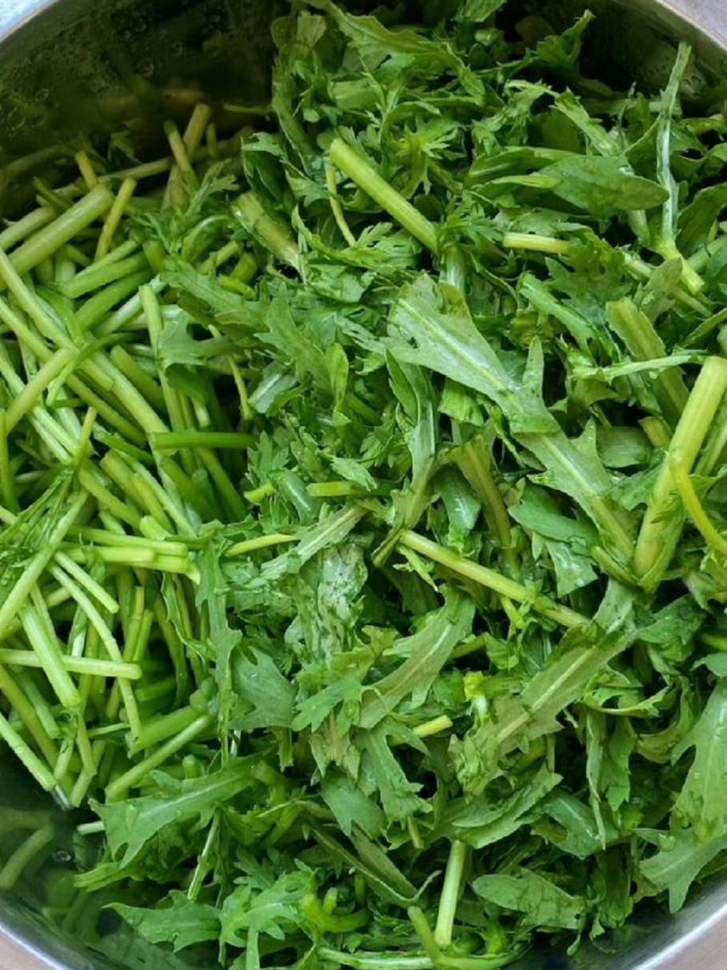 这碗鲜亮的绿色蔬菜,仿佛是春天的使者,带来了大自然的清新与活力