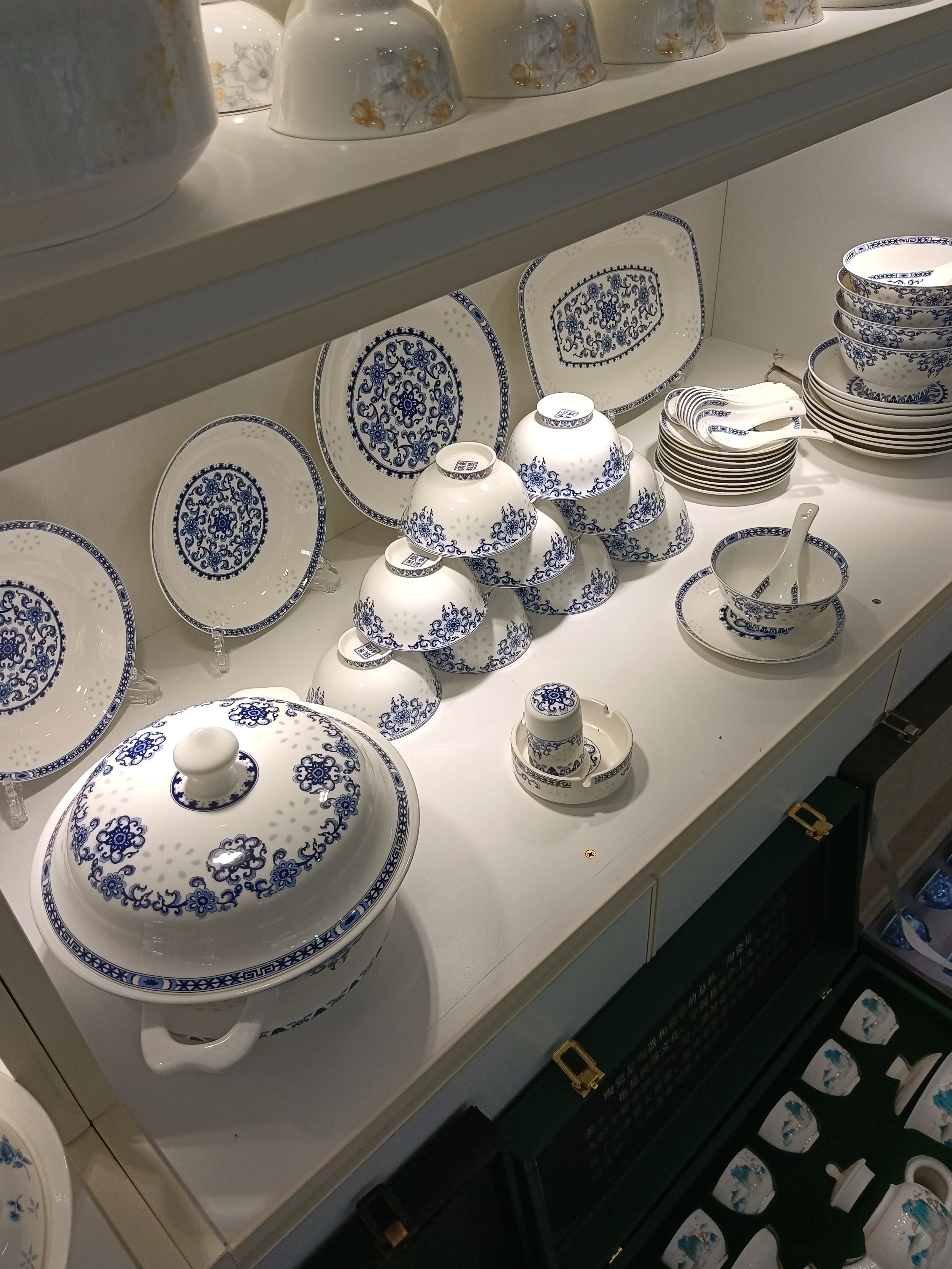 盘子,碗,杯子,汤盆,形态各异,大小错落,静静地摆放在白色的架子上.