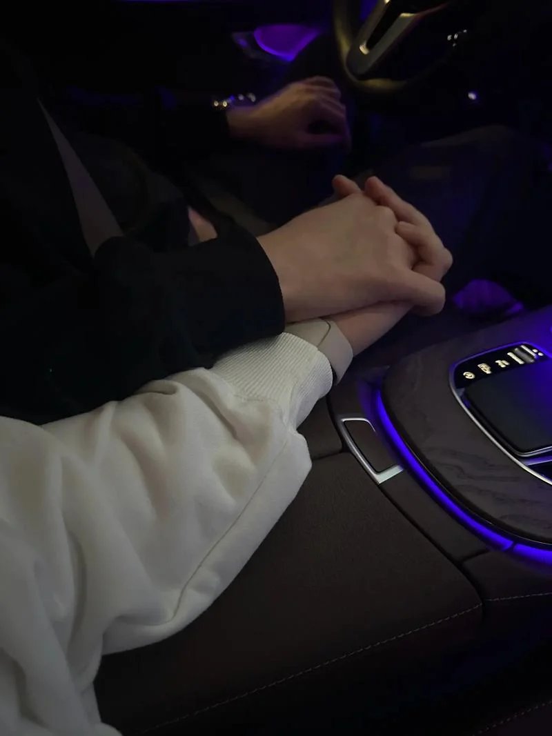 在温馨的车厢里,两个人的手轻轻交握,传递着彼此的温暖与信任
