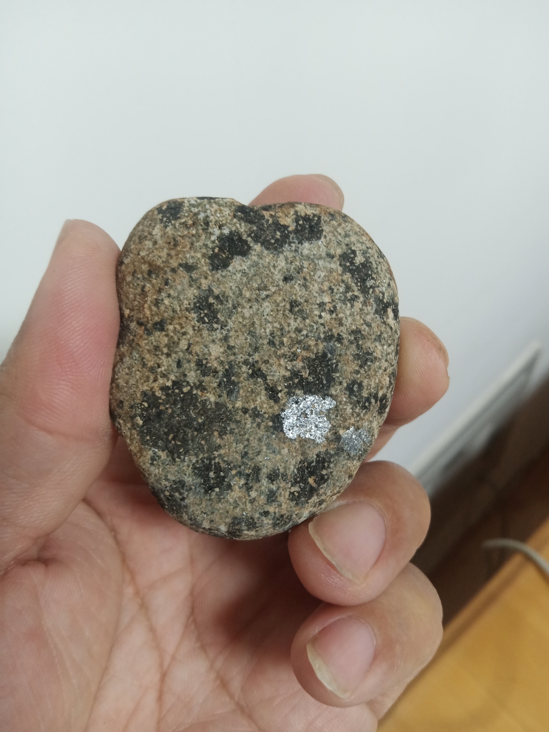 黑石头表面一层沙粒,转角度黑色还闪银色光,无磁性,不知是矿石还是