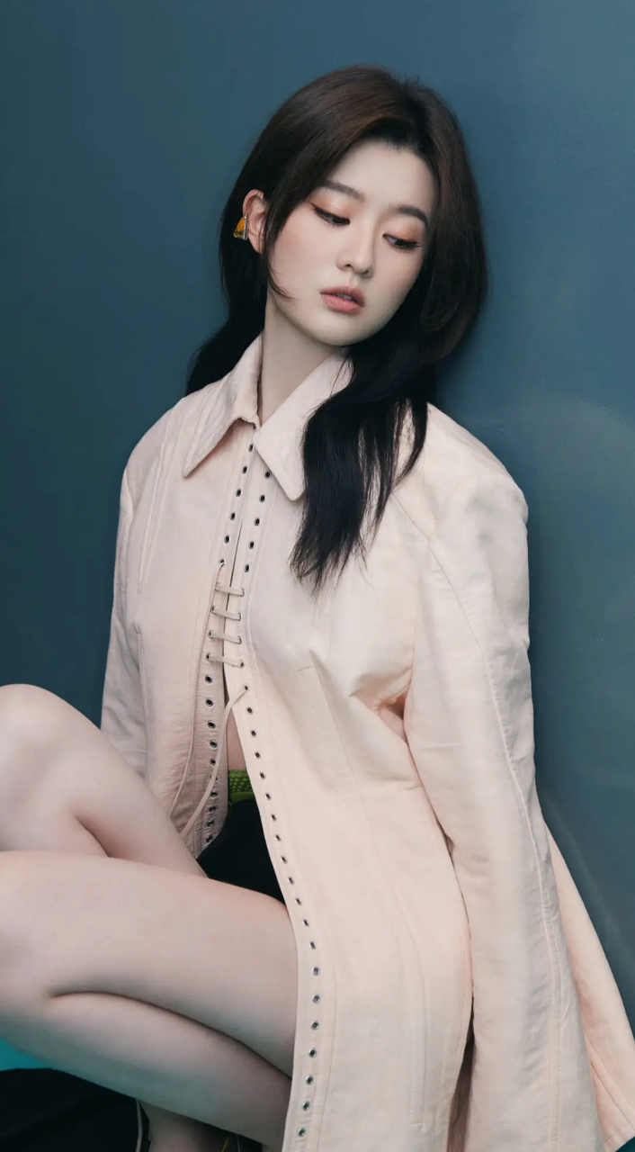 乔欣的写真大片充满了性感和妩媚的气息,她蹲下的姿势和低头的动作都