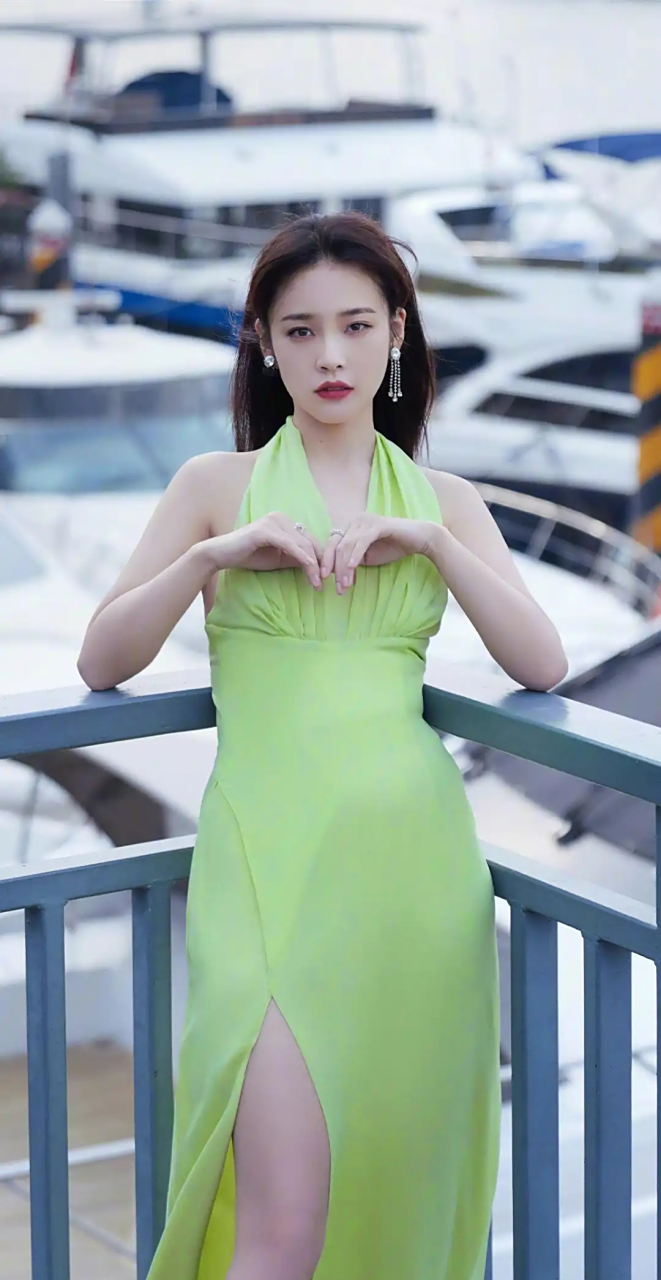 牛油果绿挂脖长裙的选择展现出了她的清新风格,开叉