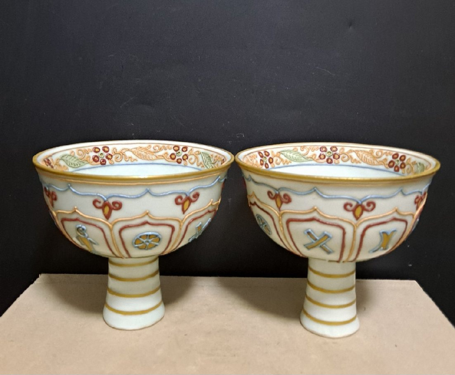 元代卵白釉沥粉堆花五彩戗金高足杯一对和碗一个,内有"金玉满堂,长命