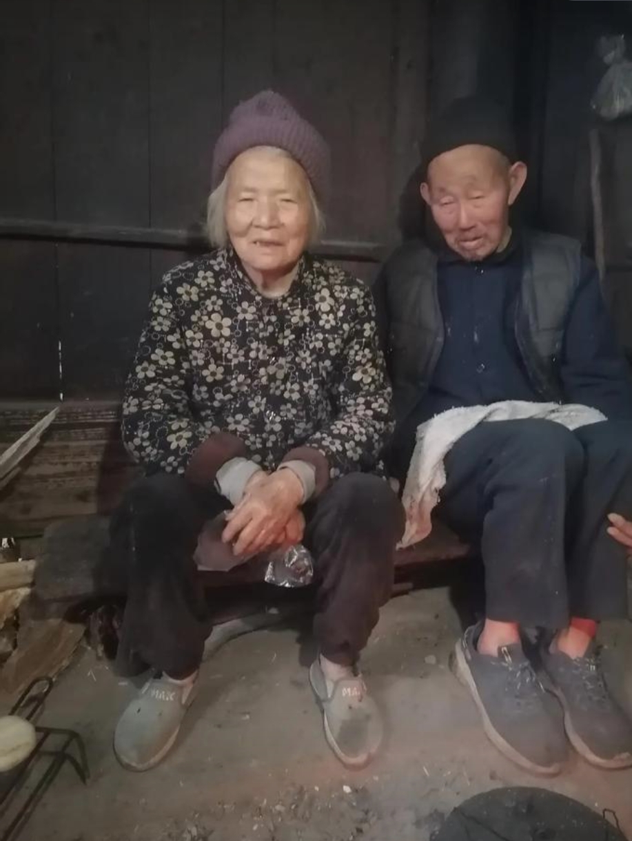 奶奶与爷爷并肩坐于古朴木凳之上,脸上洋溢着灿烂的