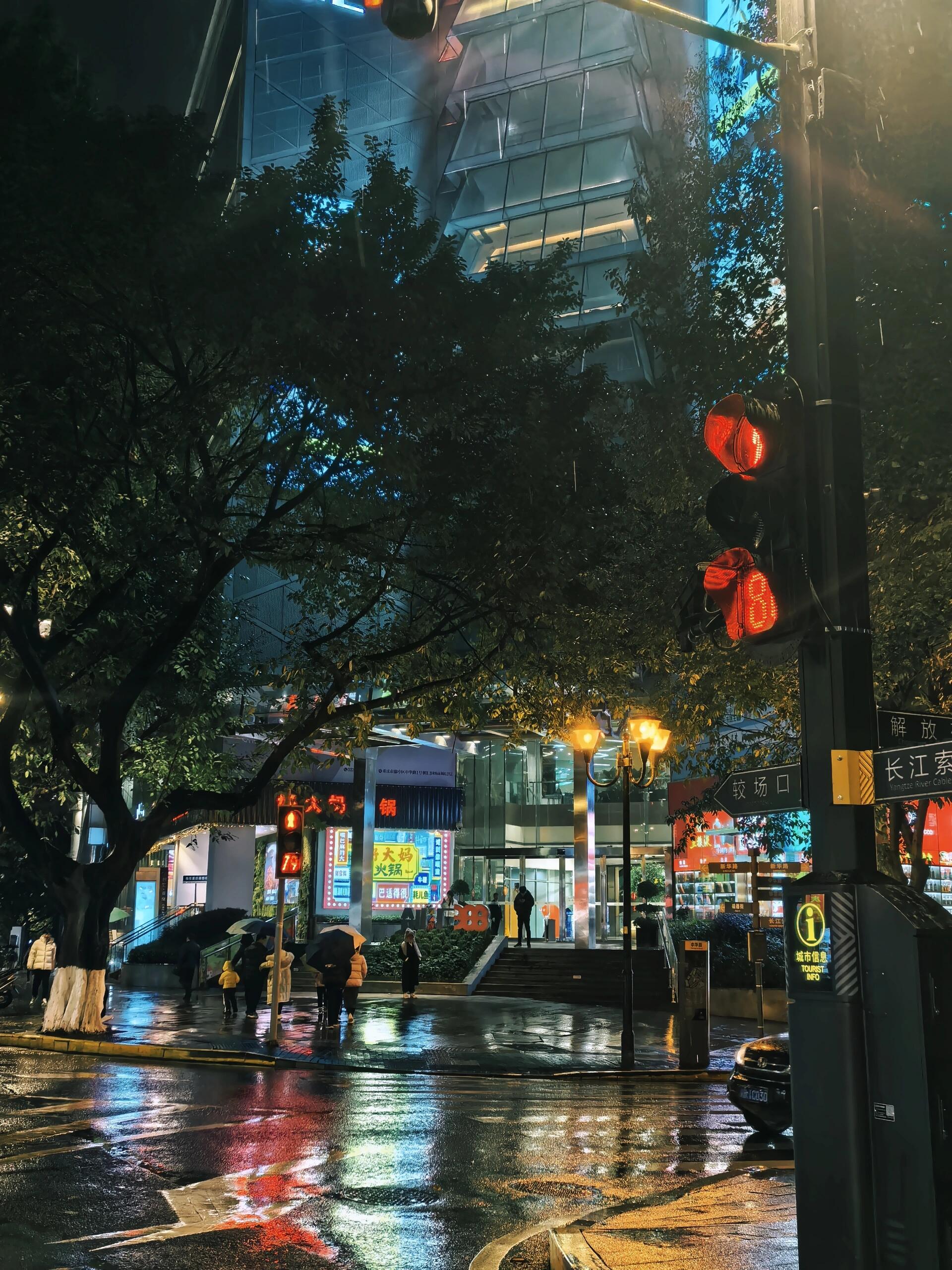 "雨夜漫步,灯光璀璨,重庆时代广场下,我们撑伞同行