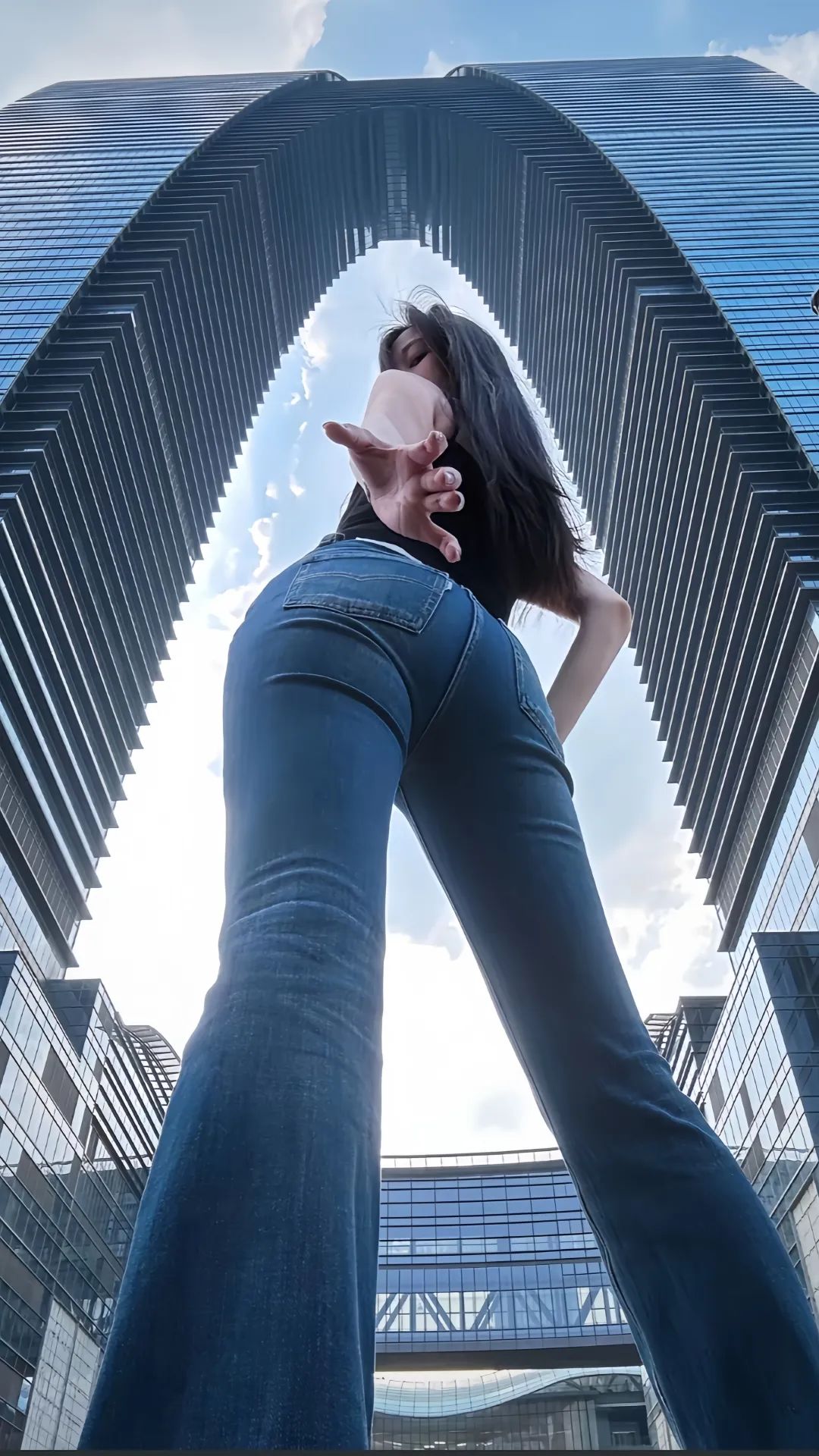 这位女士穿着牛仔裤,岔开双腿模仿秋裤楼的姿势玩自拍,来引发人们对她