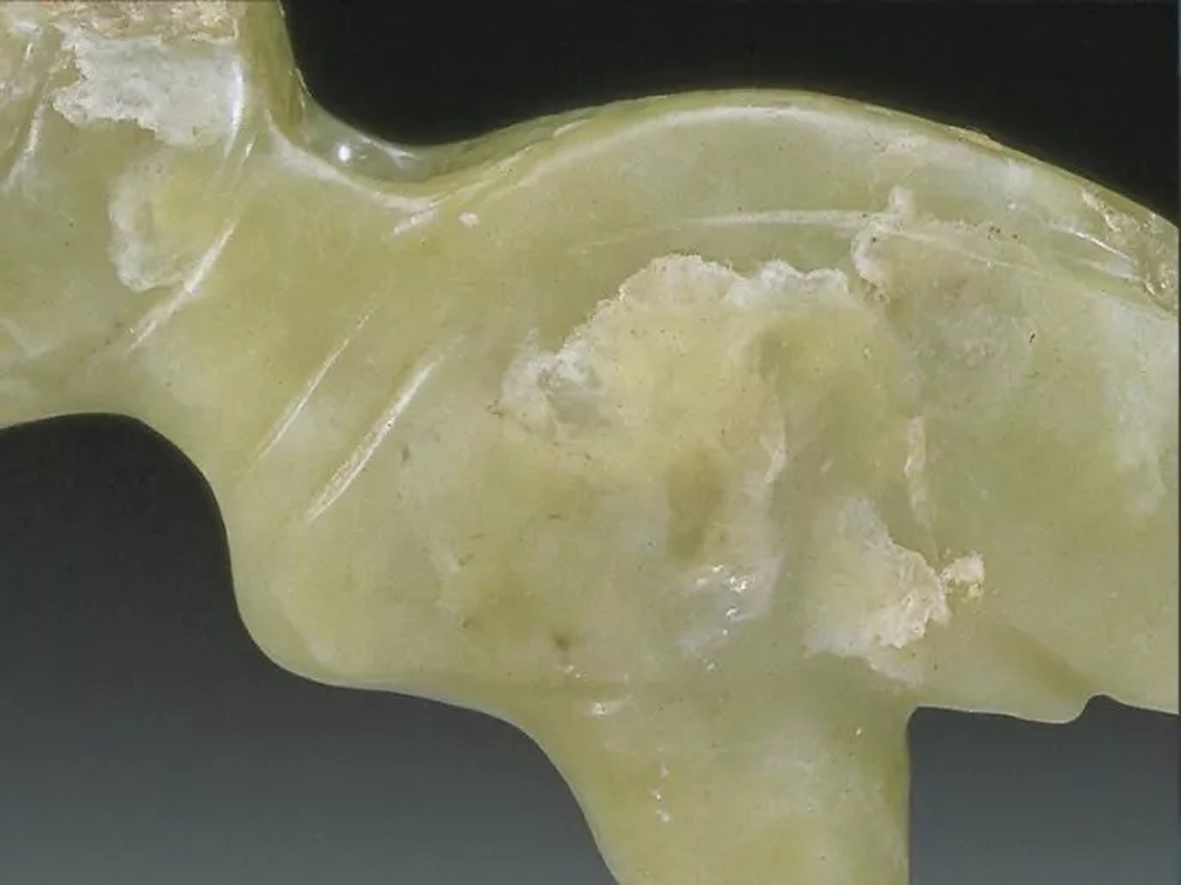 真品高古玉的冰裂纹或绺裂深入玉里,界限分明,玉表包浆与未受沁区域