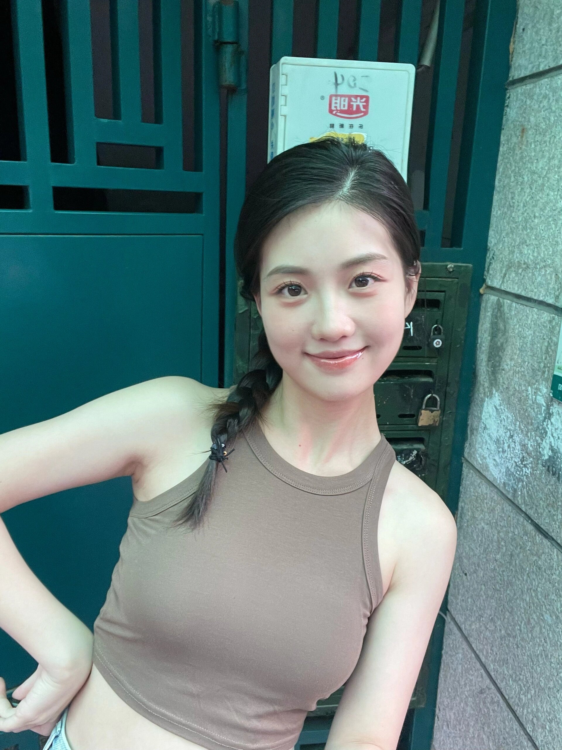 这个年轻的女孩,穿着棕色的上衣,马尾辫发型,给人一种清新自然的感觉