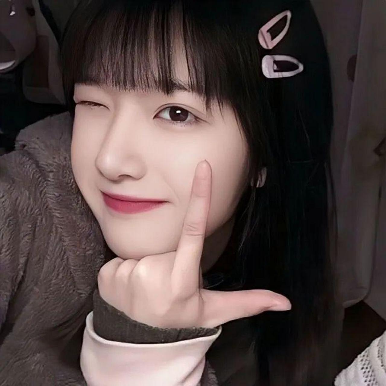 看这位年轻的女孩,瓜子脸,黑长直的头发,棕色毛衣暖洋洋的,笑起来比v