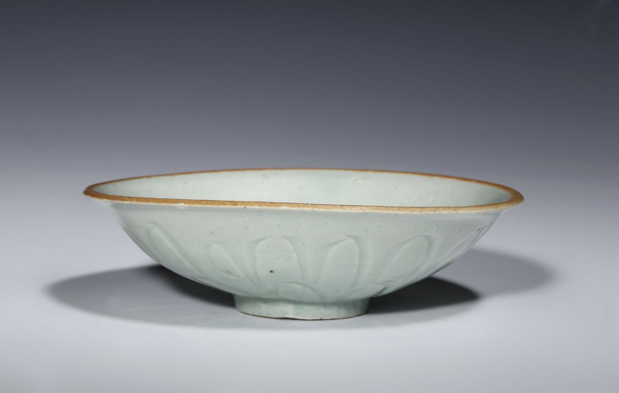 施青白釉为地,口沿,底足涩胎,釉面莹润细腻,碗内