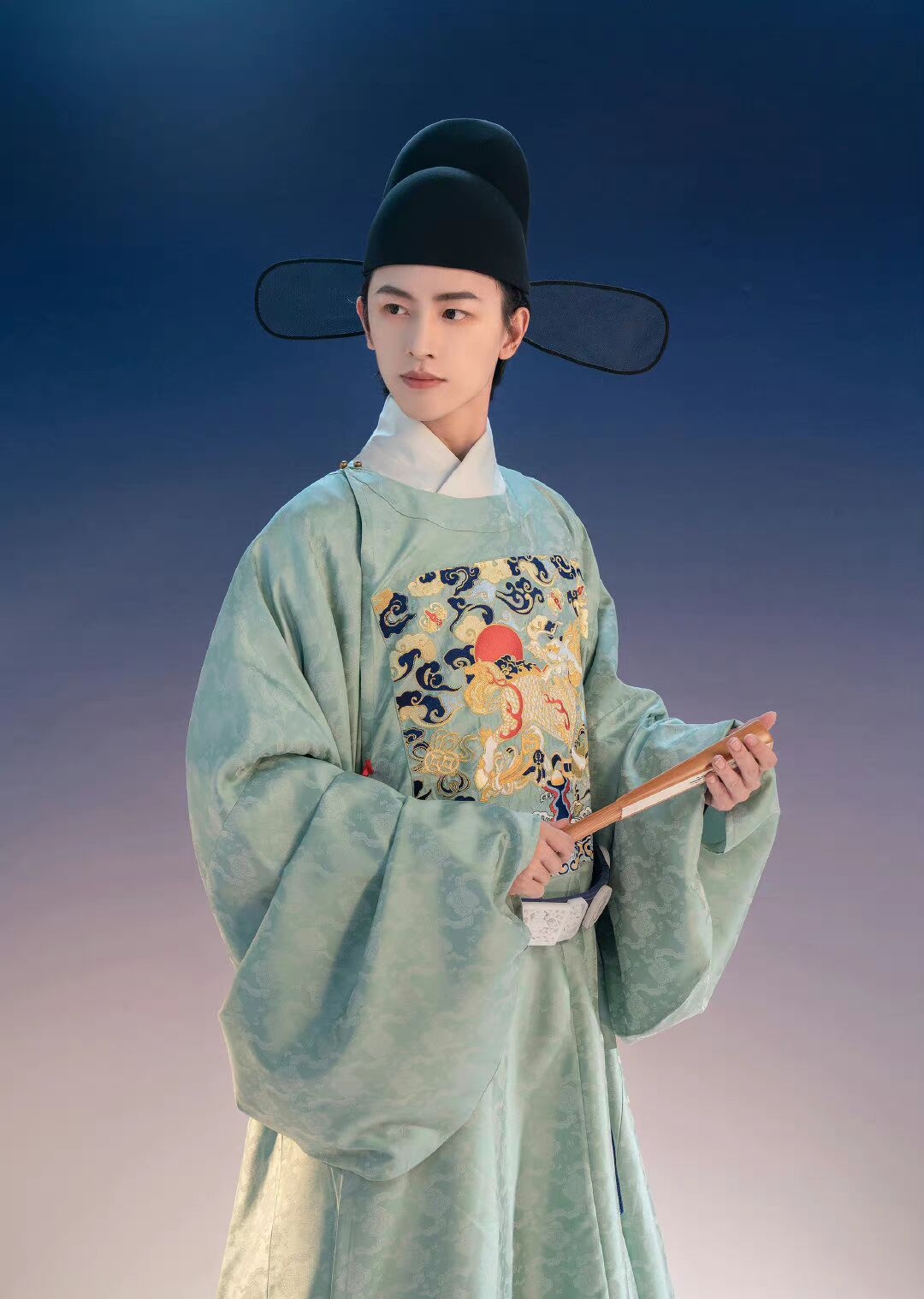 穿着明代传统服饰的青年,手持纸扇,温文尔雅,仿佛之