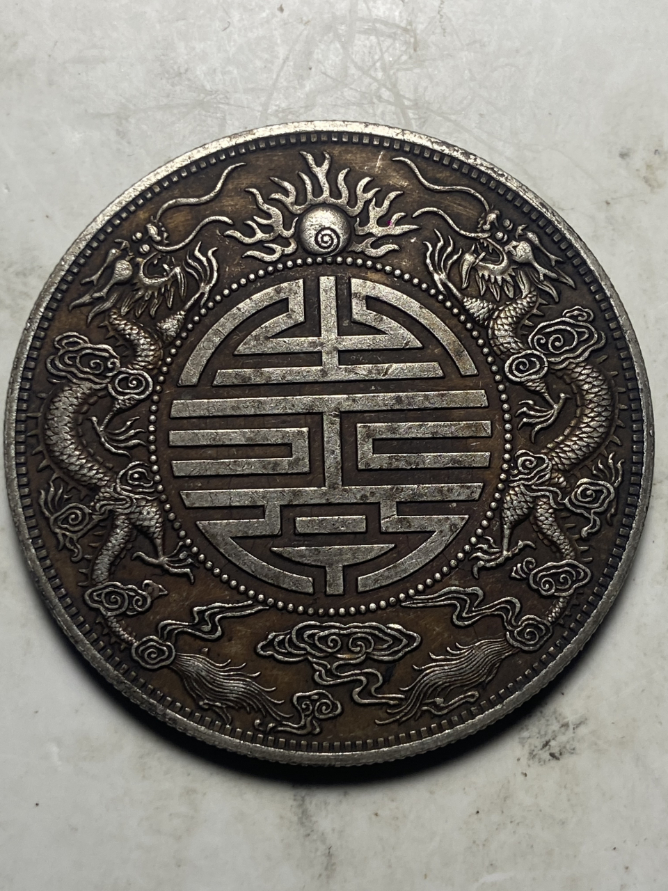 七钱二分比库平一两及其他面值双龙寿字币存世更少,究其原因,国人从尚