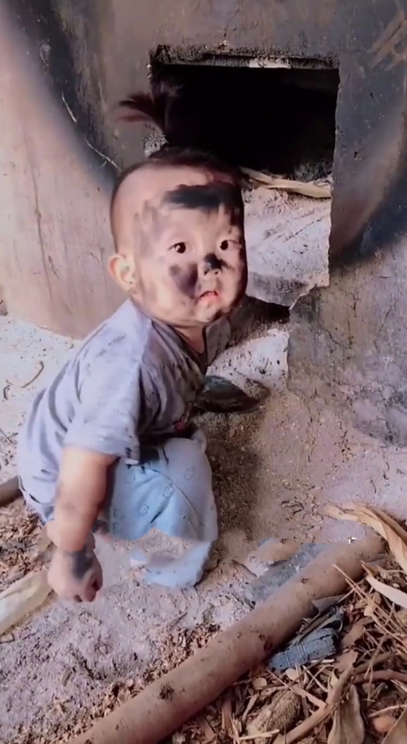 回乡下奶奶家玩,一不留神就跑到灶台去玩灶灰,等