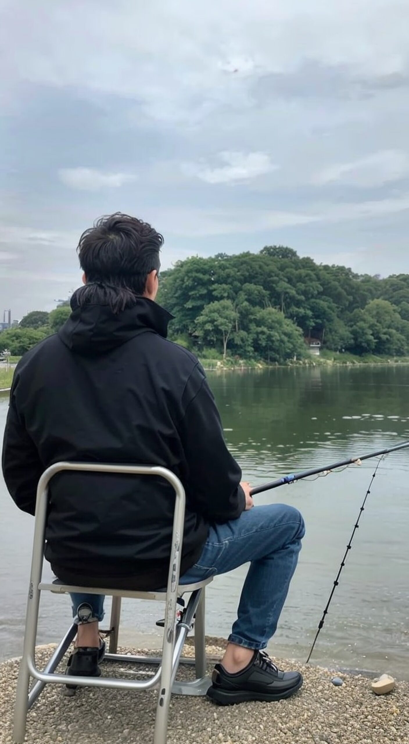 人生正当时# 钓鱼佬的日常🎣  坐在椅子上的男人,旁边放着鱼竿和