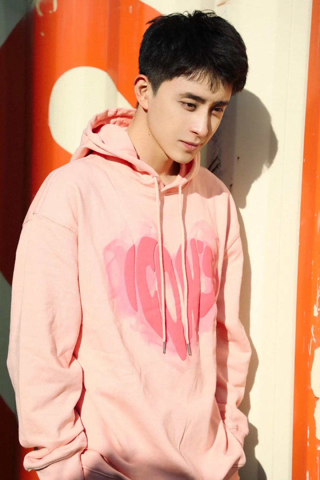 粉色卫衣,短发轻扬,每个细节都洋溢着少年的活力