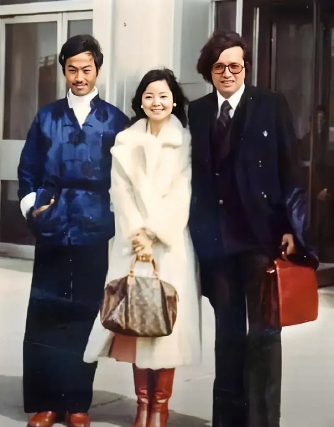 照片中,25岁的邓丽君站在两位男子中间,脸上挂着甜甜的笑容