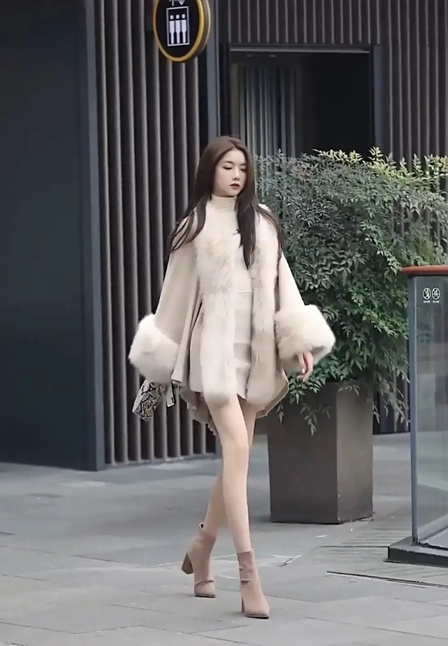 来看一位穿着时尚的美女,成都春熙路,一位身穿貂皮毛领大衣配高跟靴