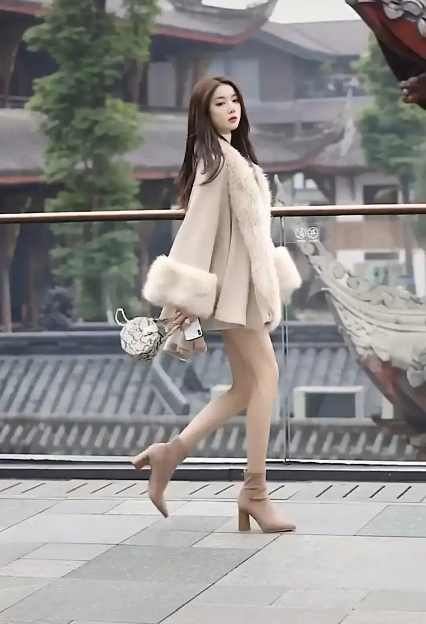 来看一位穿着时尚的美女,成都春熙路,一位身穿貂皮毛领大衣配高跟靴