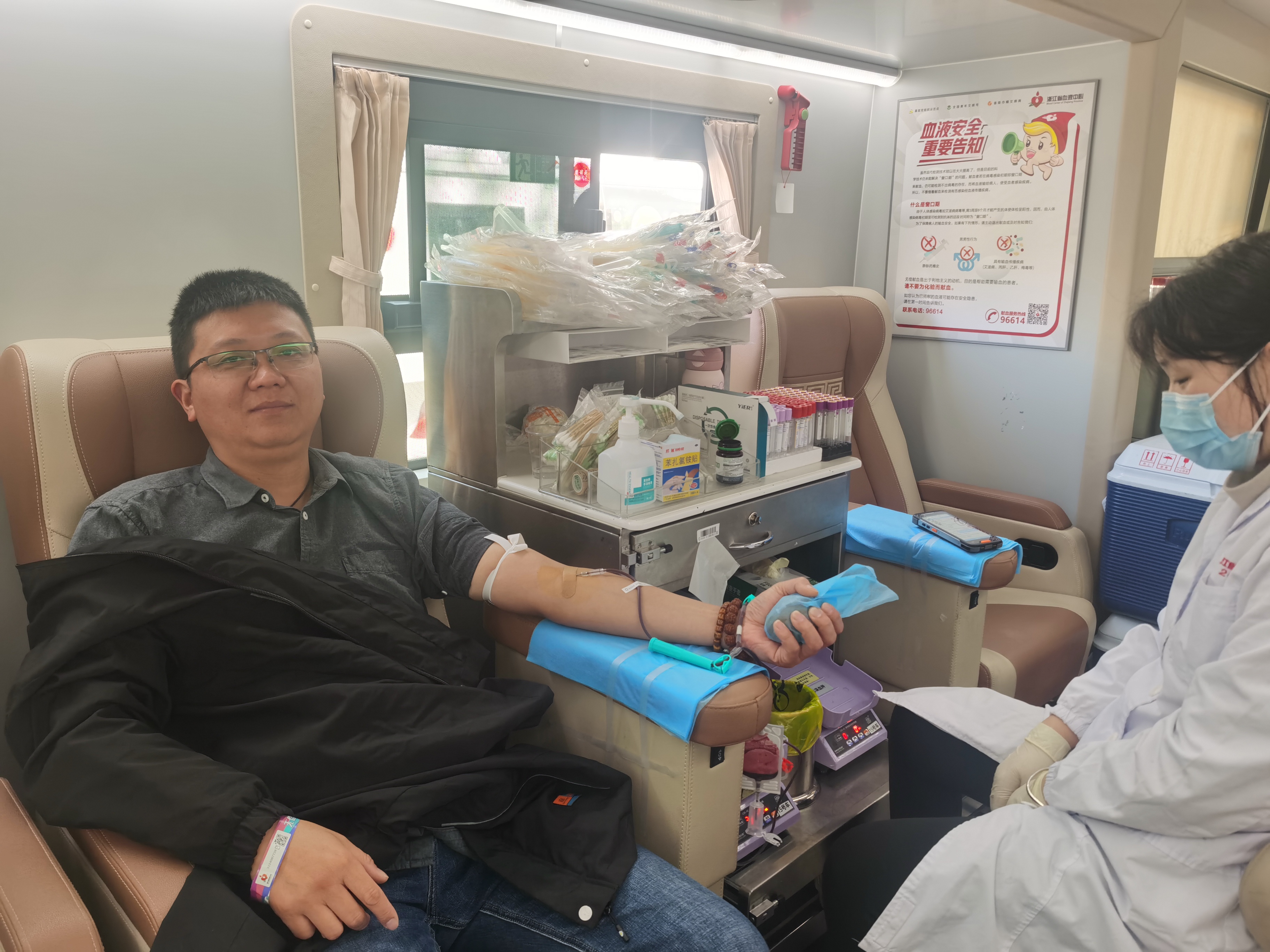 一幕令人感动的献血画面,这位男士的手臂坚定地被固定在血袋架上,仿佛