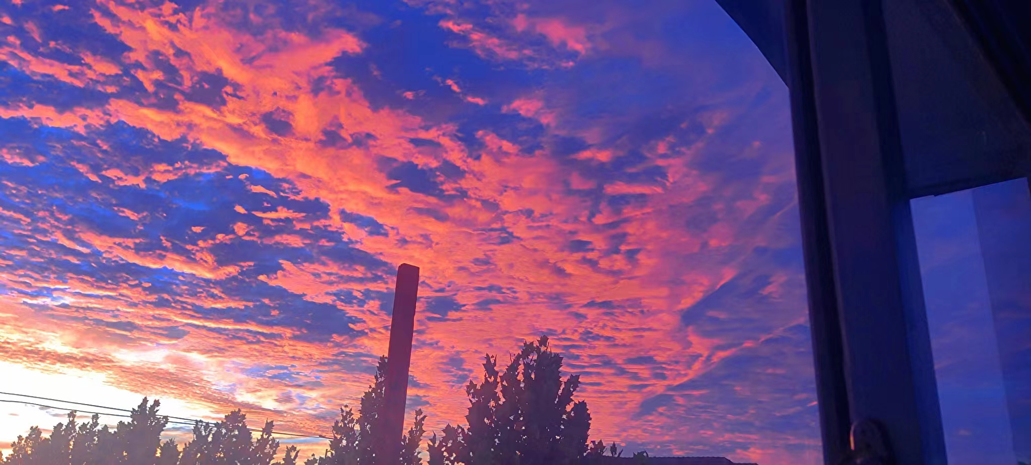 天空被晚霞染成了梦幻般的色彩,橙红与蓝紫交织,如同调色盘上的奇迹.