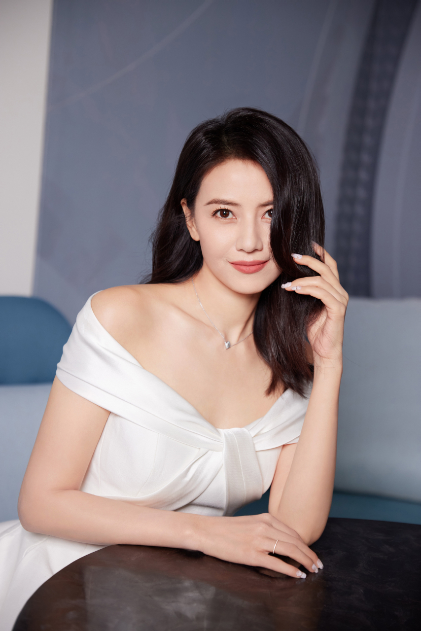 生活需要诗意,也需要优雅高圆圆身穿白裙,黑发飘逸,坐在蓝沙发上,宛如