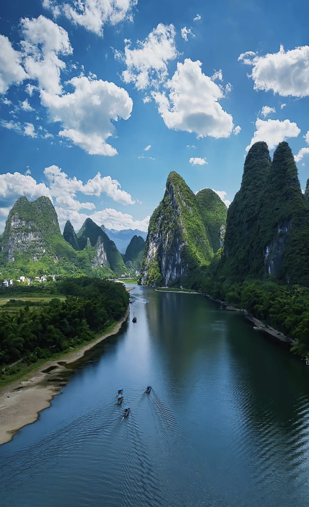 深蓝色的河水宛如一条丝带,穿越在翠绿的山丘间.