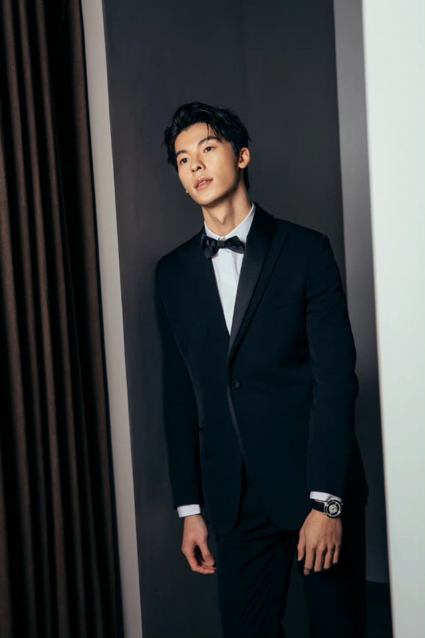 许光汉身穿经典的黑色西装搭配白色衬衫和点睛的黑色领结,成熟稳重不