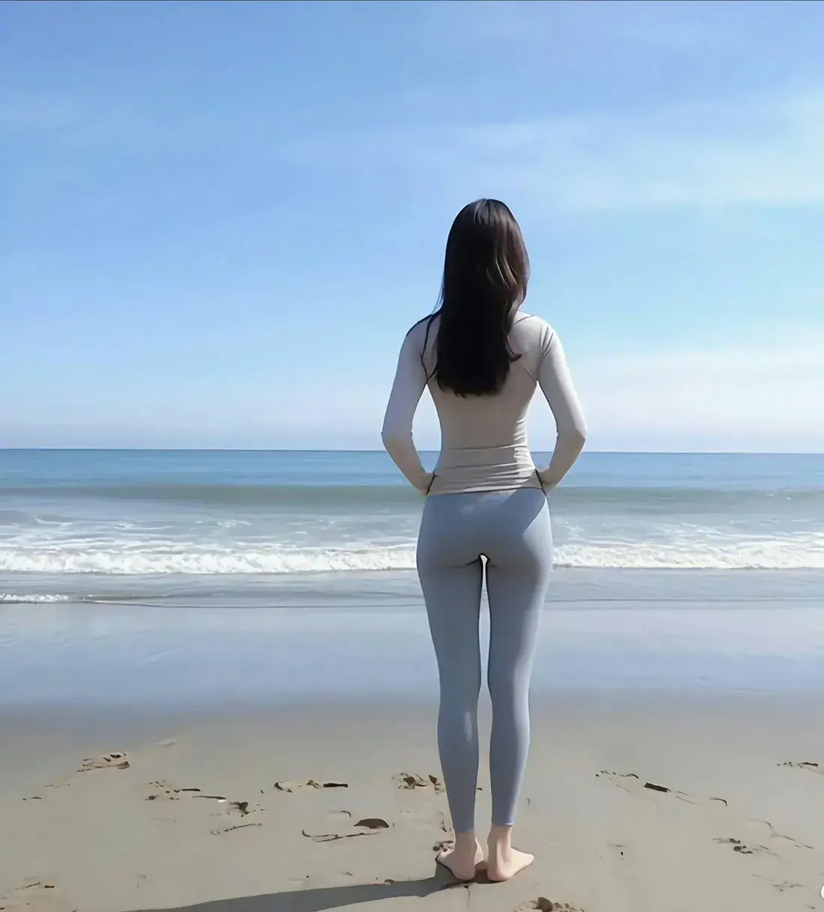 灰色紧身瑜伽裤与白色长袖上衣的完美搭配,展现出优雅与力量并存的