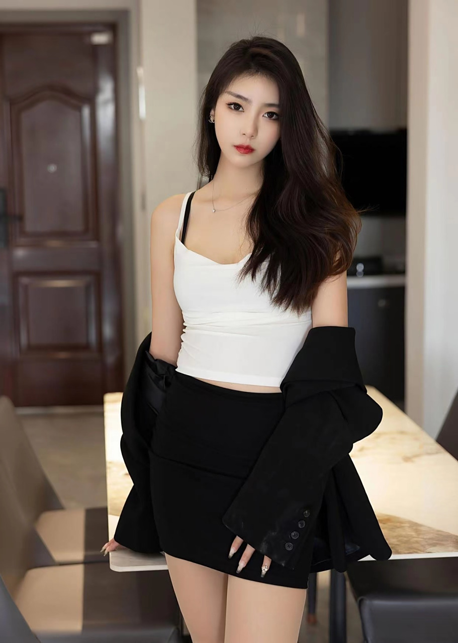 飘逸的长发,丰盈多姿的苗条身段下,白色收身上衣搭配黑色短裙,尽显