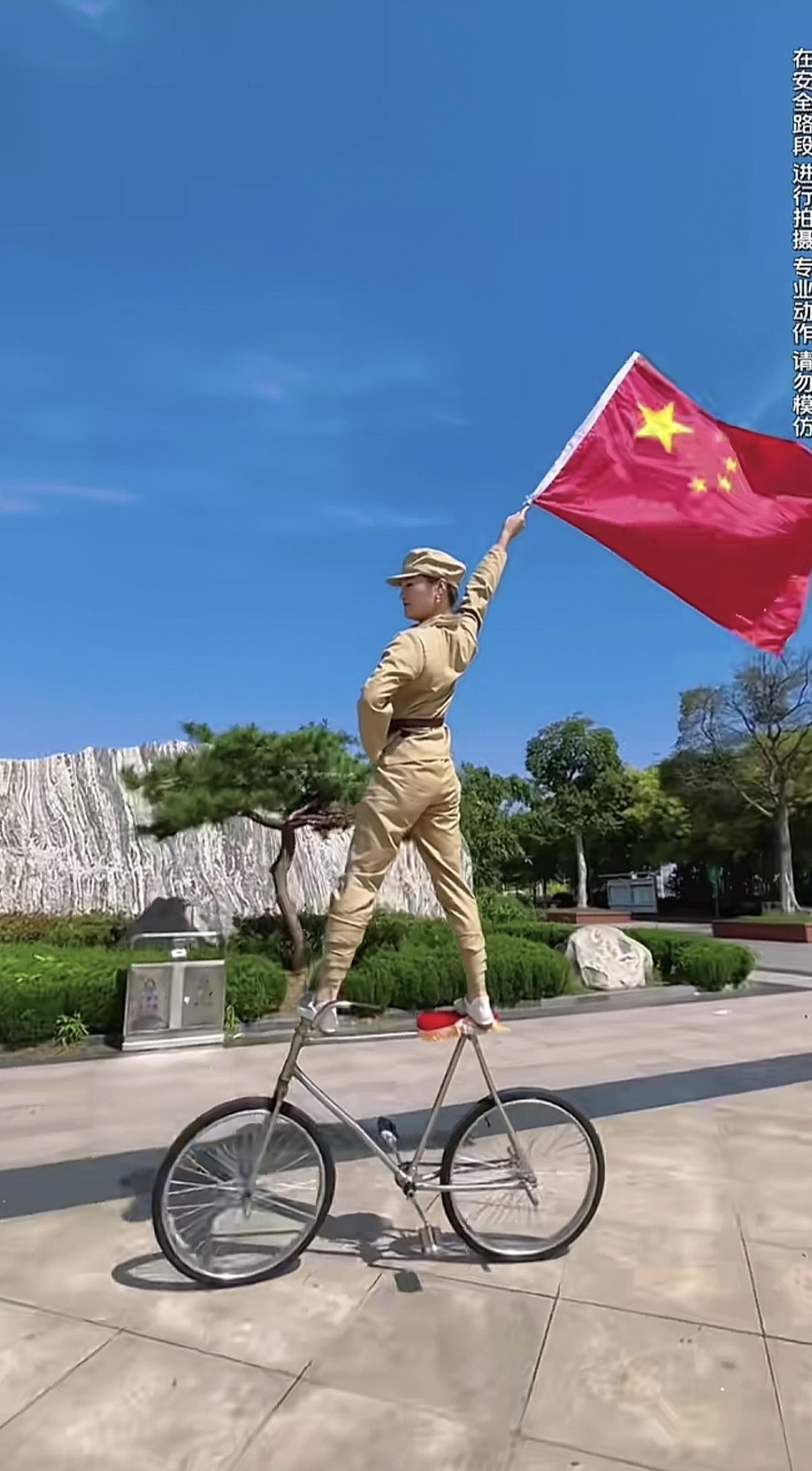这美女姐姐真是身手不凡!在自行车上高举红旗纪念祖国生日!