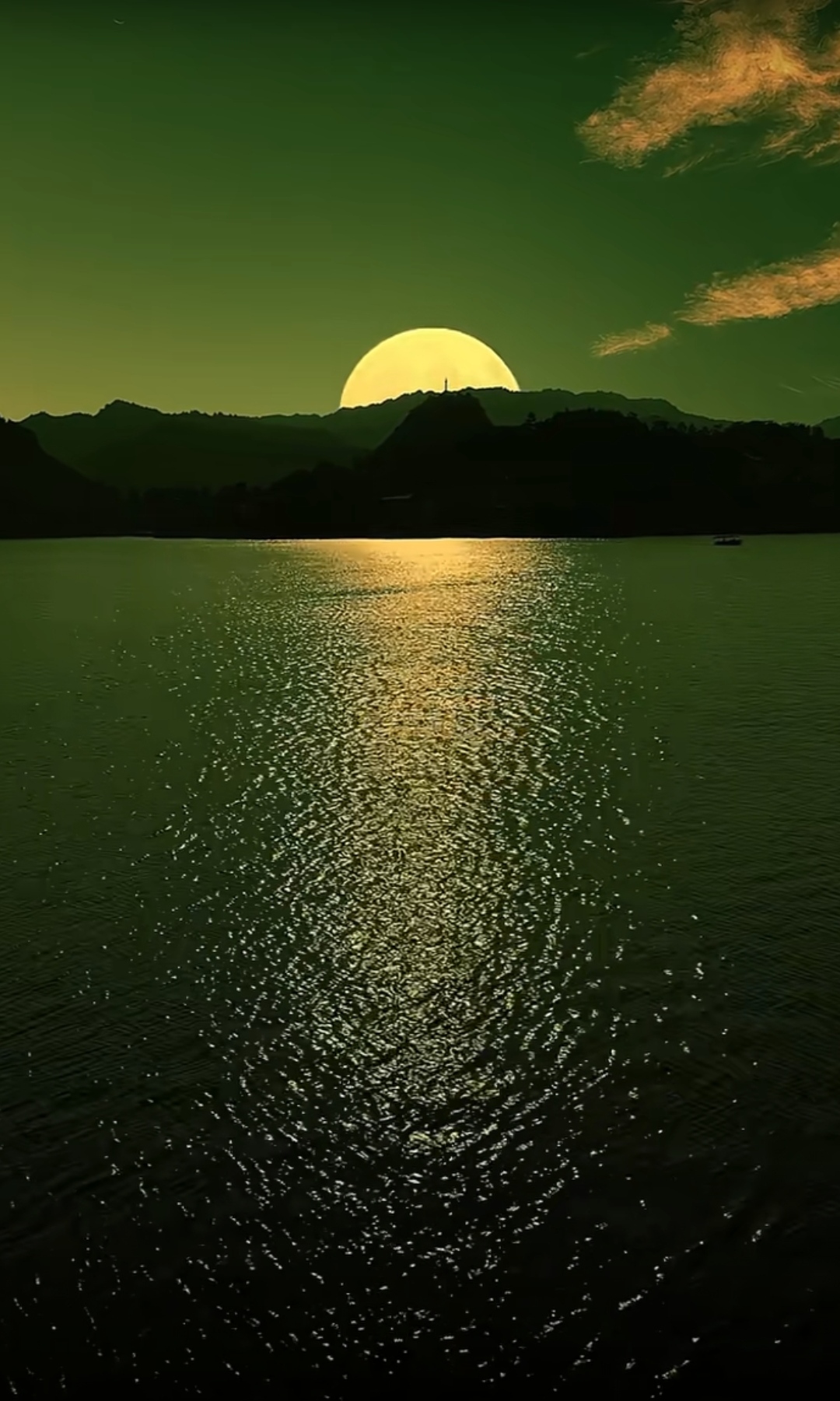 夜幕降临,湖面波光粼粼,一轮明月一纵一纵地慢慢冒出水面,悬挂天上