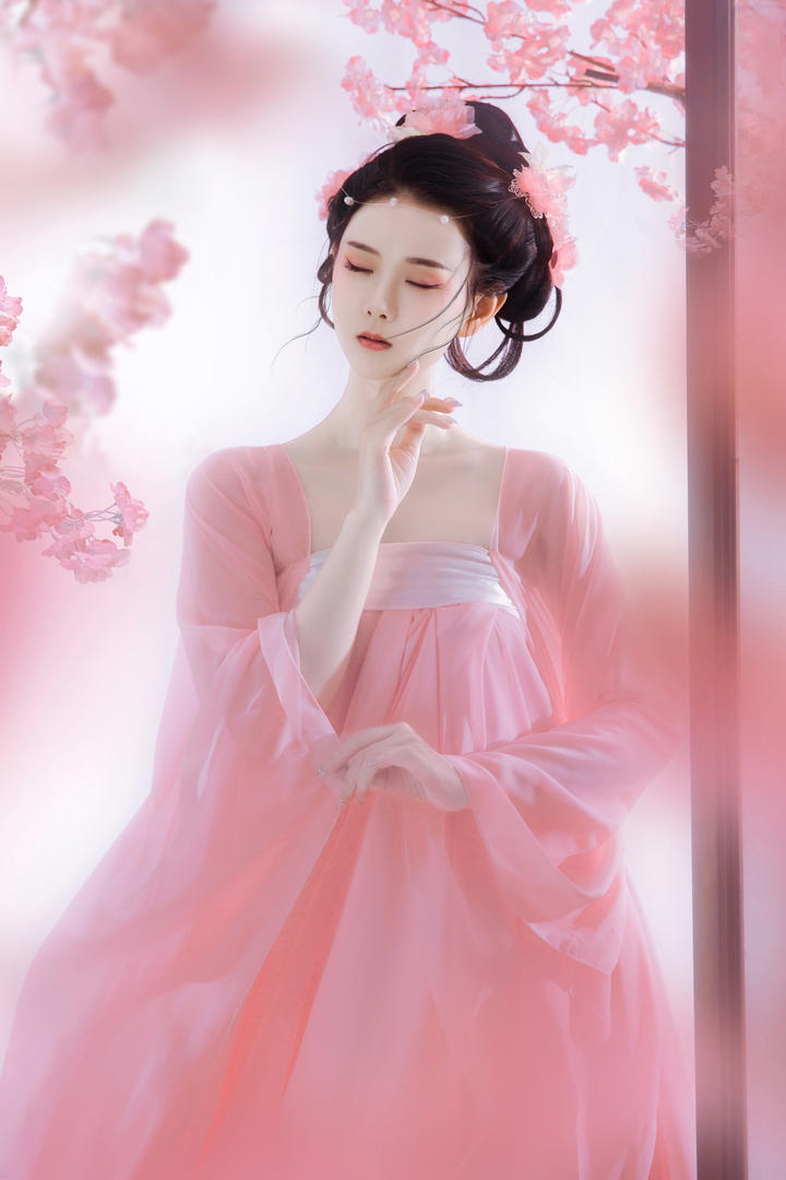 949494樱花树下,一名女子身着粉色古装,仿佛穿越时空而来.