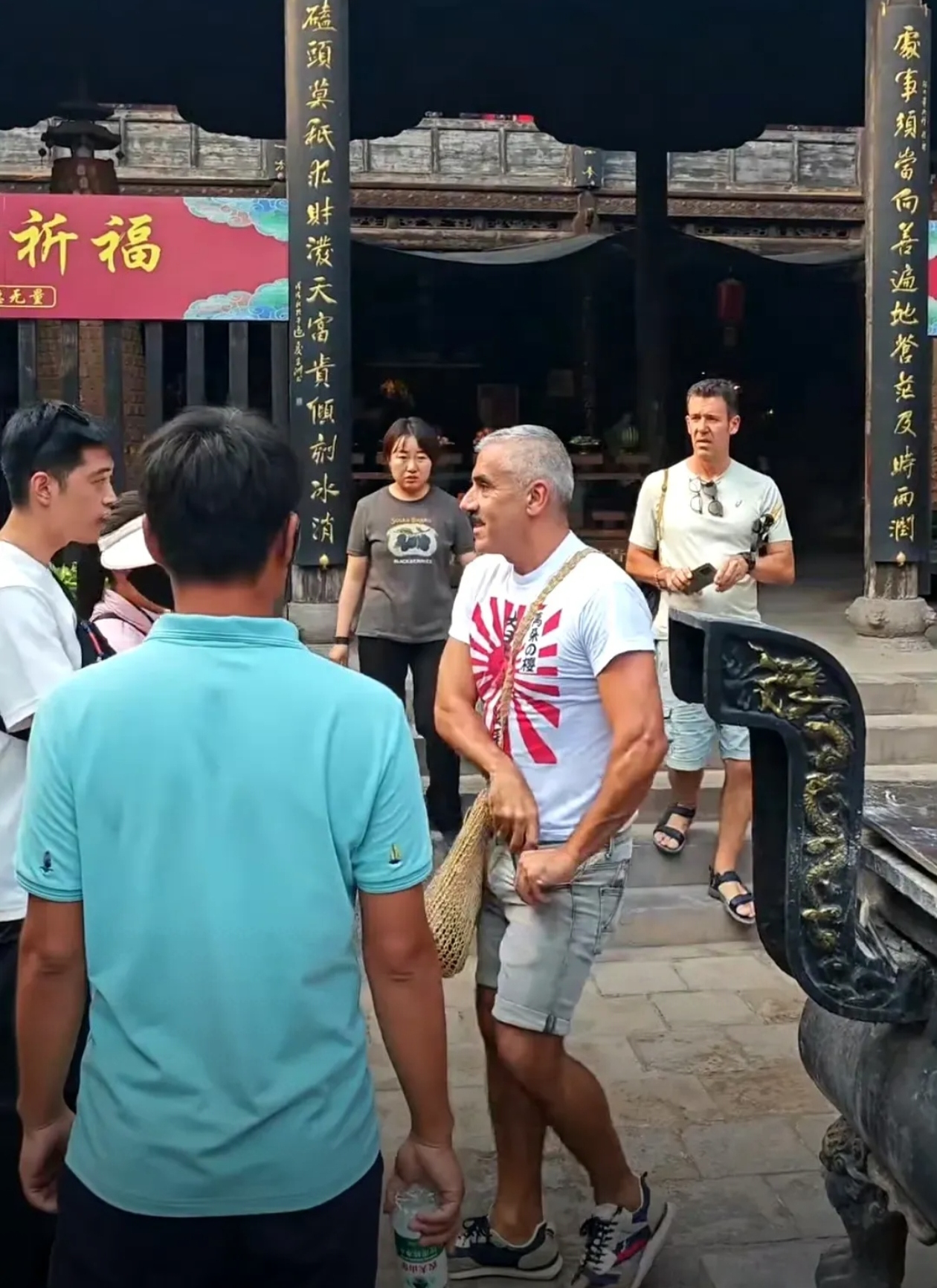 近日,在平遥古城,一名外国人穿着旭日旗的衣服,引起了中国小伙的注意