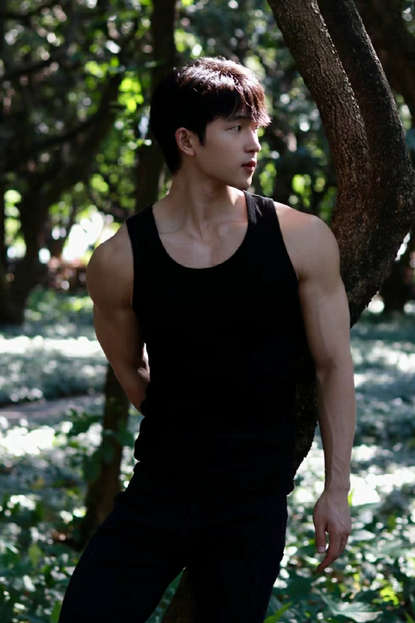 黑色背心,肌肉线条清晰可见,仿佛是大自然的雕刻家精心雕琢的作品.