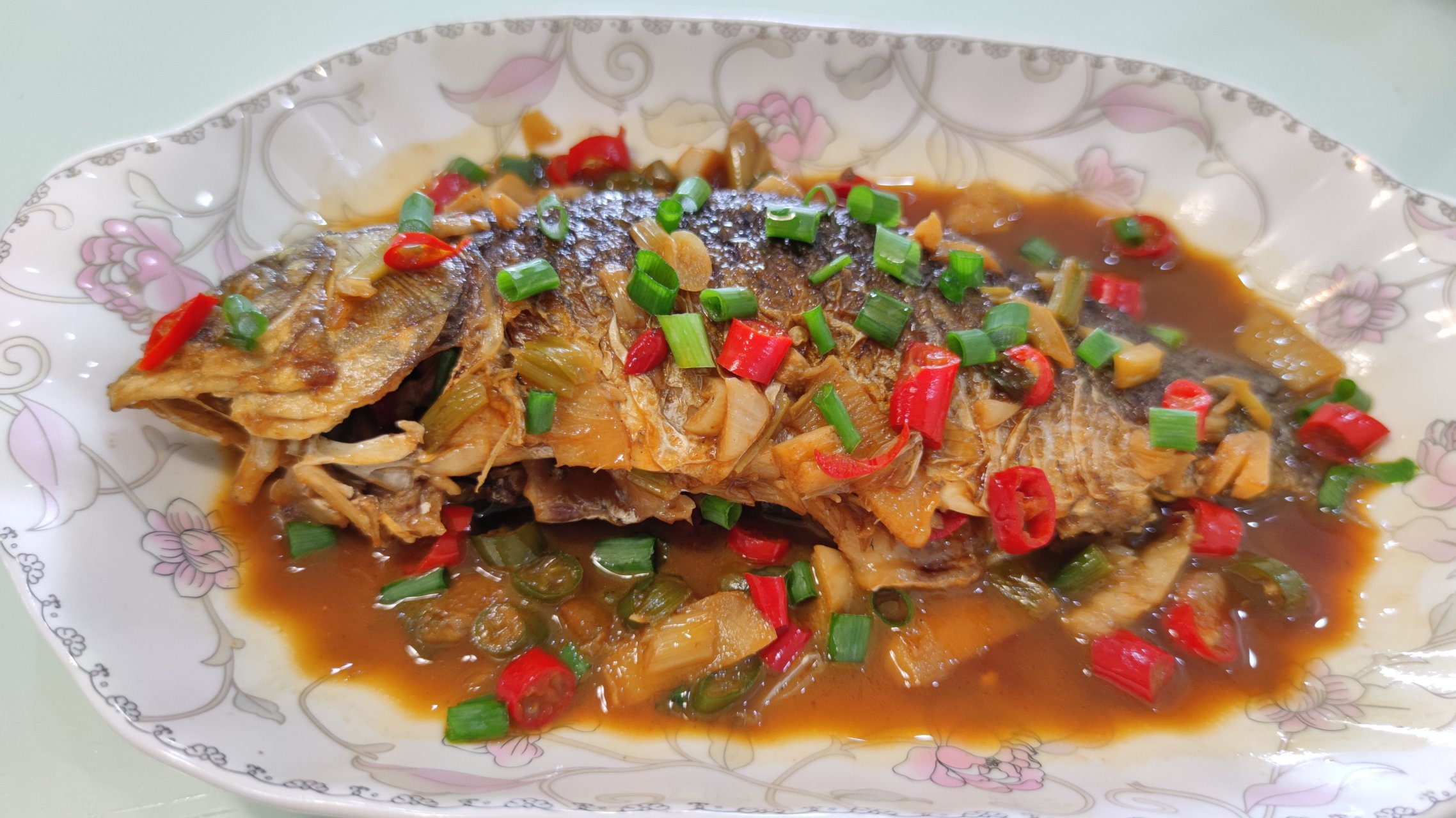 红烧鲫鱼的做法:  1,先准备需要的食材:葱,姜,蒜,小米辣和鲫鱼.