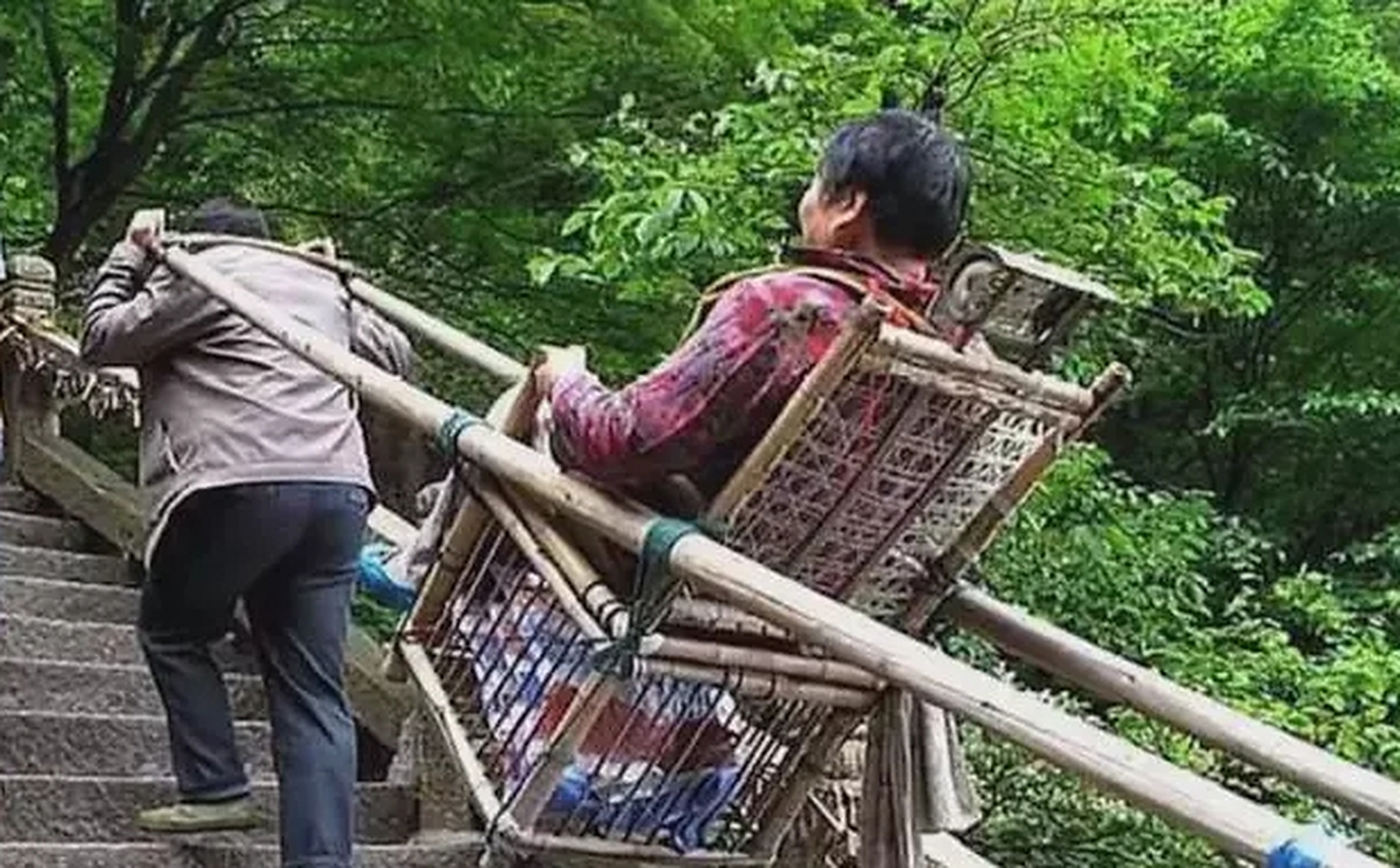 大妈在景区爬山,因为走得太累了决定搭乘人工抬轿,轿夫表示每人收费