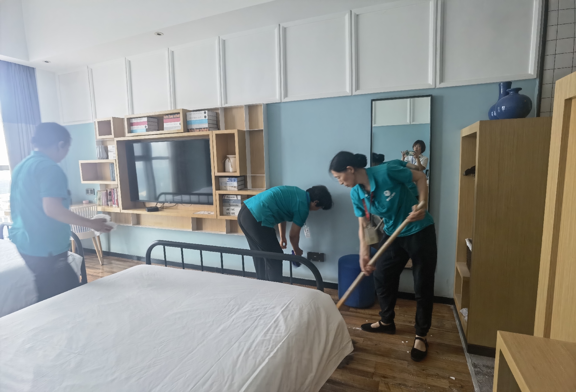 大家一起干的热火朝天 其乐融融 三个人正在认真打扫一间酒店房间