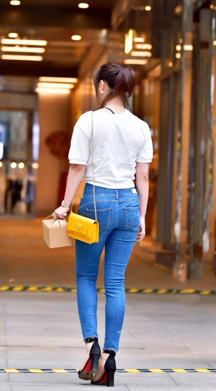 时尚街拍# 蓝色牛仔裤修长裤型好看,配上时尚黑色高跟鞋,瞬间提升