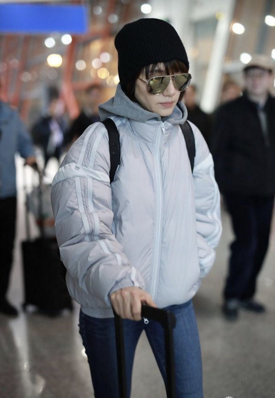 明星旧图穿搭鉴赏: 袁泉身穿银色羽绒服搭配牛仔裤,简单保暖又好看