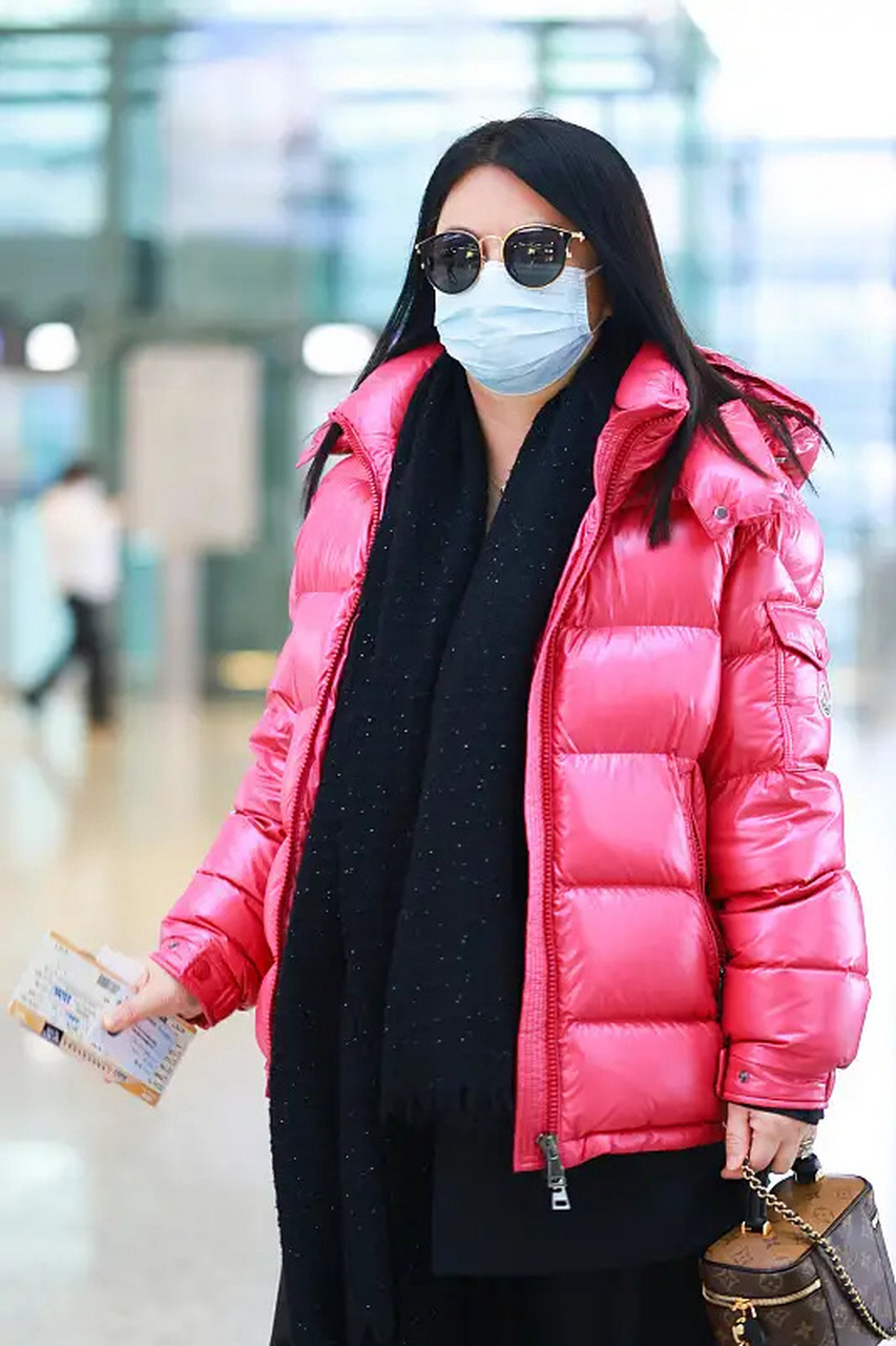 李湘最新机场照,她穿了一件玫红色的短款面包羽绒服,内搭一件黑色的