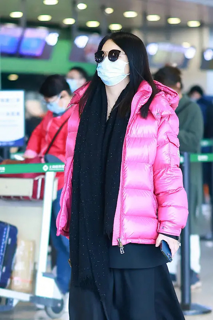 李湘最新机场照,她穿了一件玫红色的短款面包羽绒服,内搭一件黑色的
