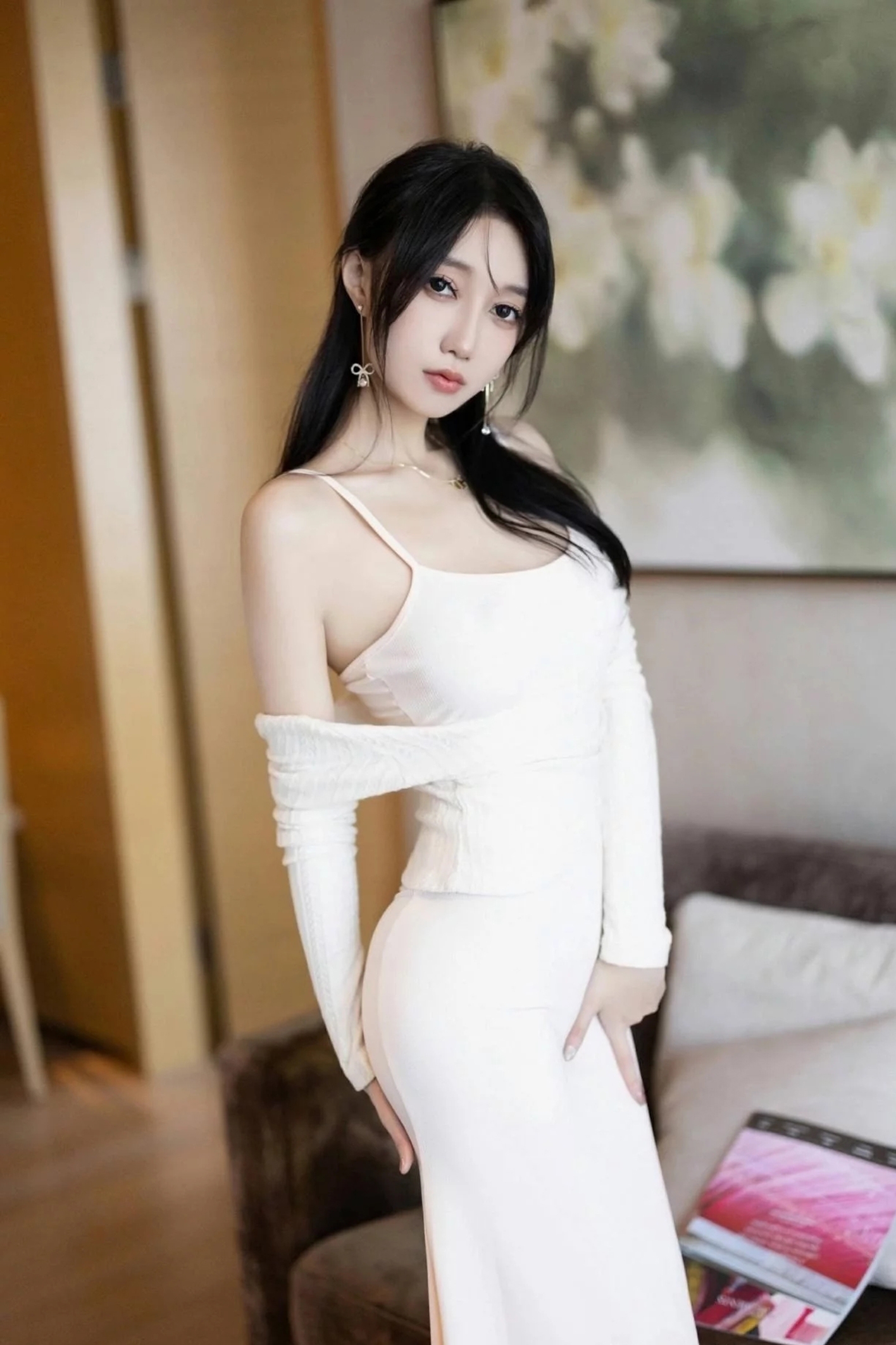 美女身穿一条白色的吊带长裙搭配洁白的丝袜高跟鞋尽显优雅气质