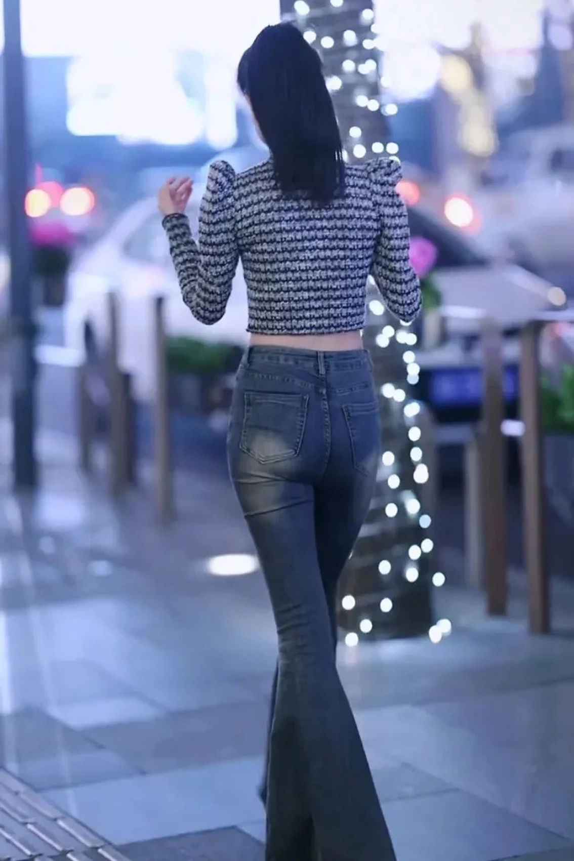 笑容甜美的美女身穿紧身牛仔裤与高跟鞋凸显苗条身材,气质高雅有魅力.