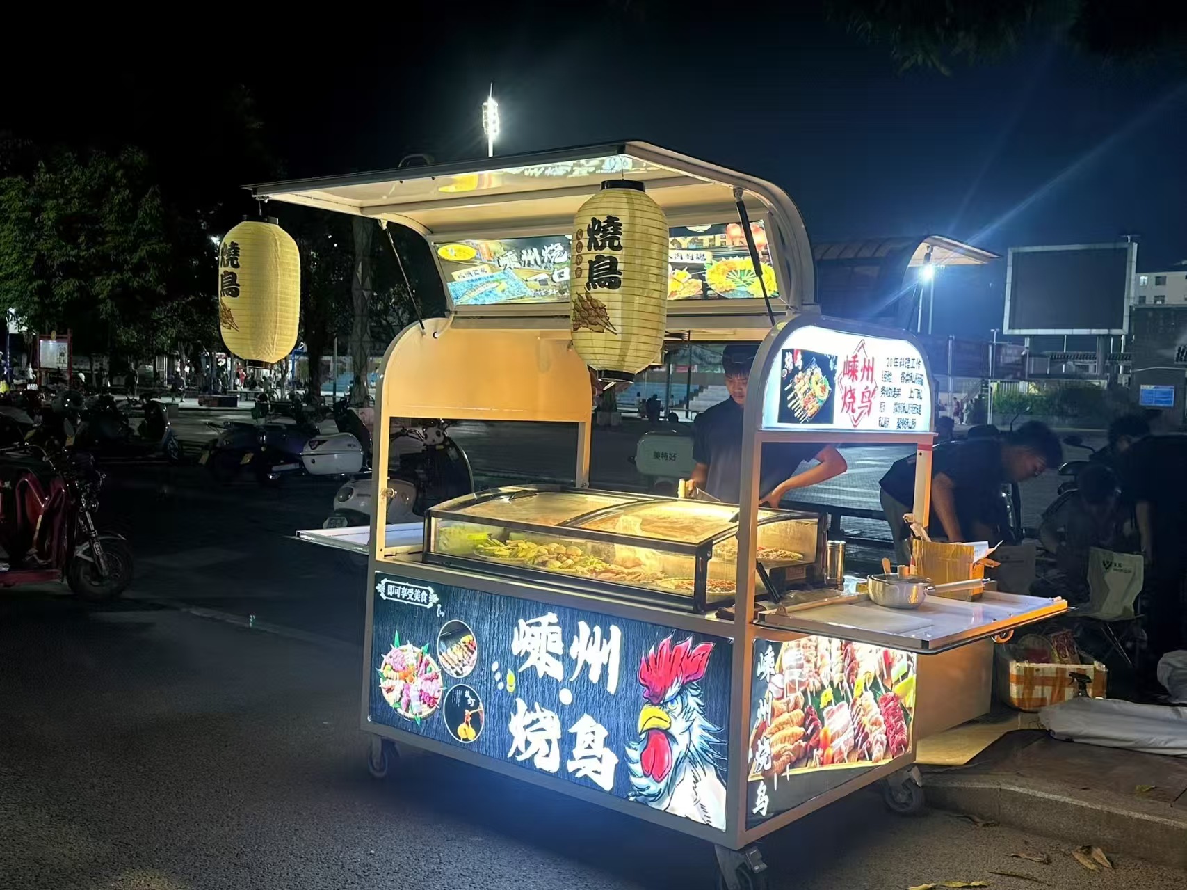 夜幕降临,街头美食的灯光亮起,吸引着人们的目光