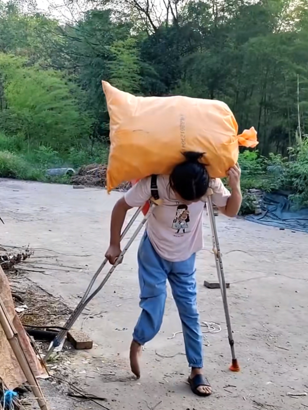 她虽双腿残疾,行动不便的身躯在田埂间显得有些踉跄,但每一步都走得